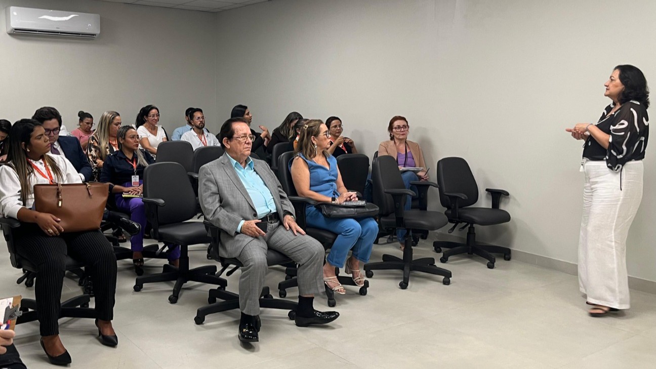 grupo de pessoas sentadas em cadeiras em um auditório pequeno